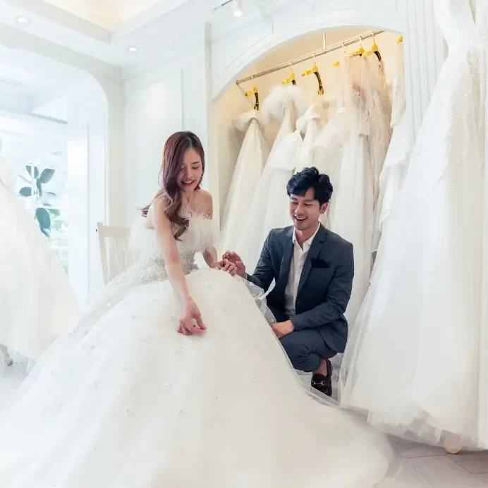 Couple choosing wedding dress in bridal shop.